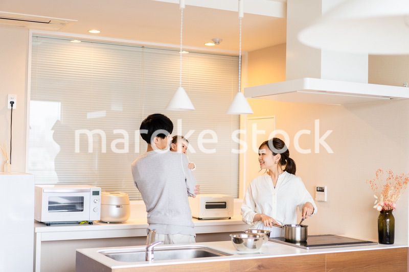 キッチンで料理をするお母さんとお父さんと赤ちゃん