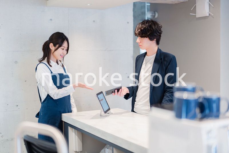 カフェでクレジットカード決済をする男性