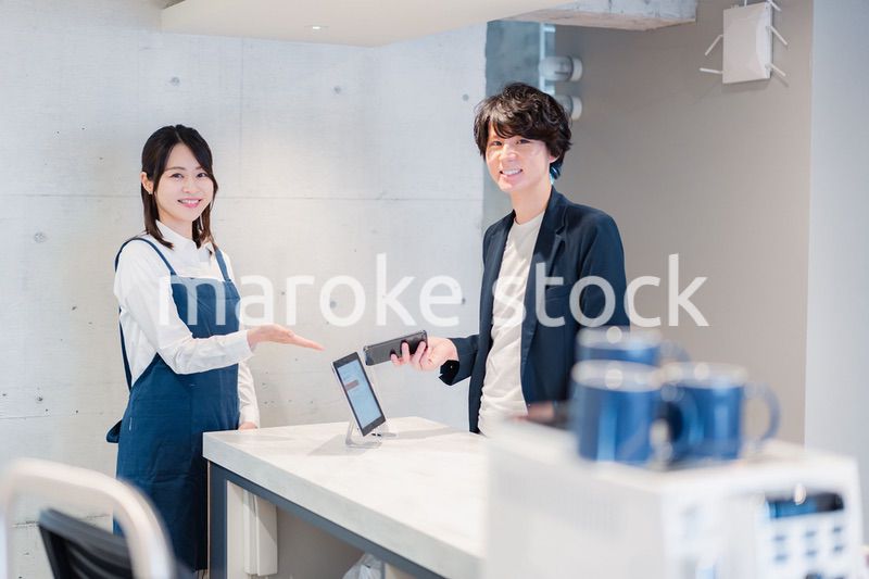 カフェでクレジットカード決済をする男性