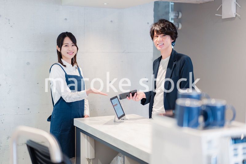 カフェでクレジットカード決済をする男性