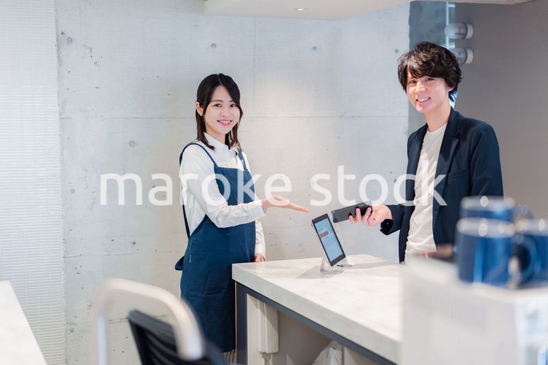 カフェでクレジットカード決済をする男性