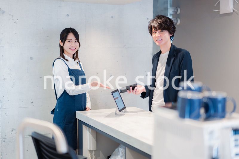 カフェでクレジットカード決済をする男性