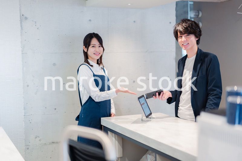 カフェでクレジットカード決済をする男性