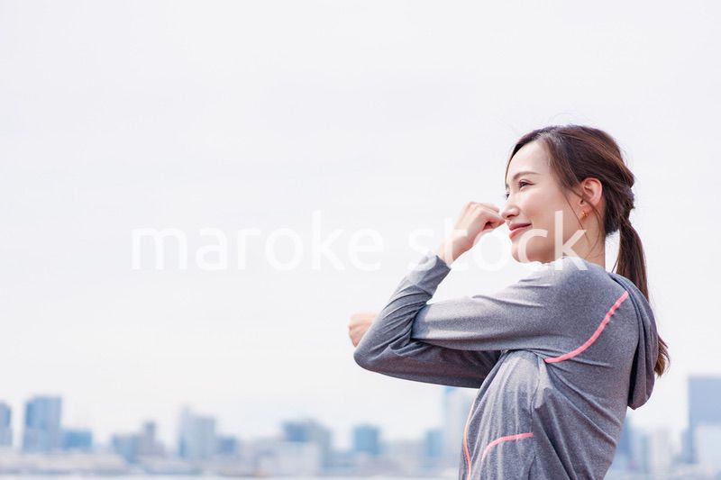 屋外でストレッチをする若い女性