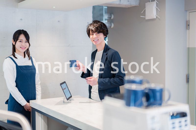 カフェでクレジットカード決済をする男性