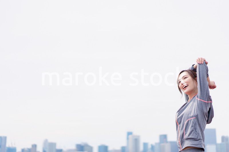 屋外でストレッチをする若い女性