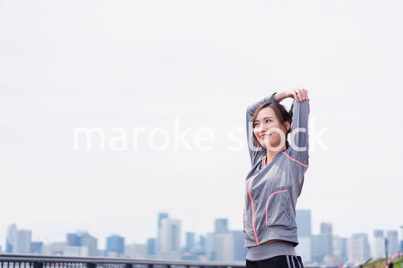 屋外でストレッチをする若い女性