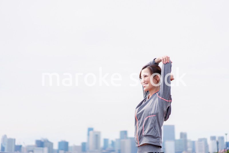 屋外でストレッチをする若い女性