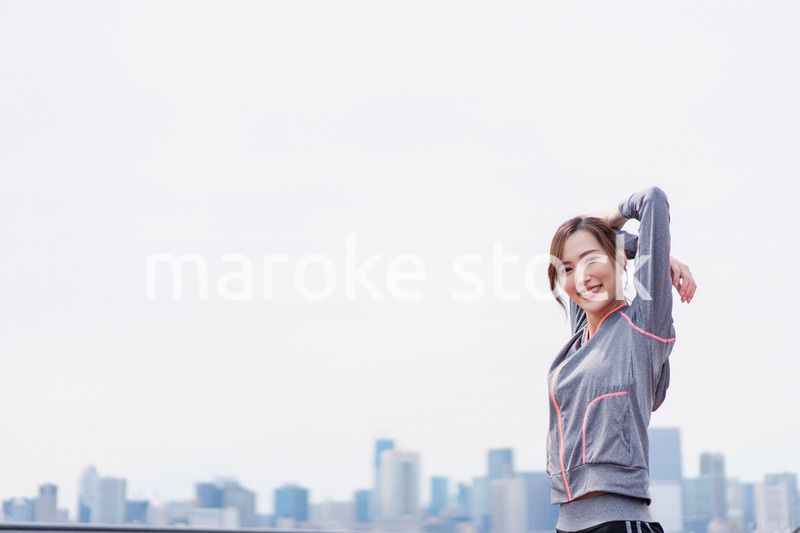 屋外でストレッチをする若い女性