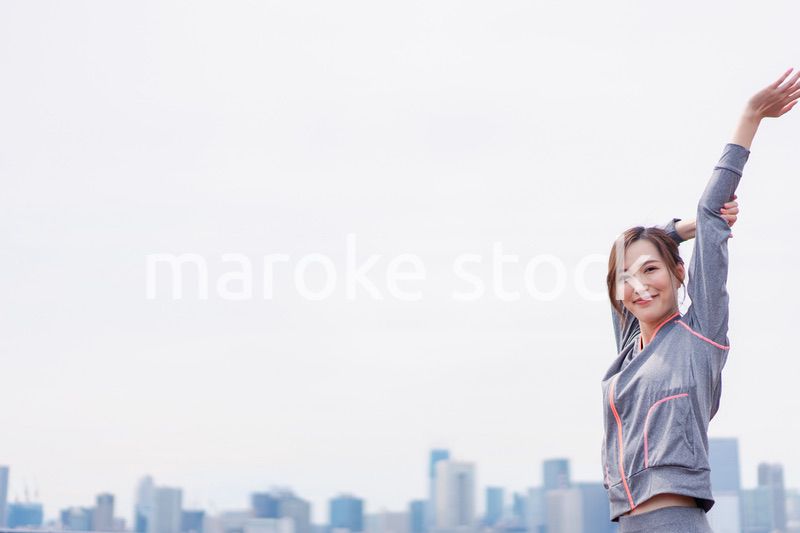 屋外でストレッチをする若い女性