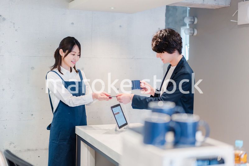 カフェでクレジットカード決済をする男性