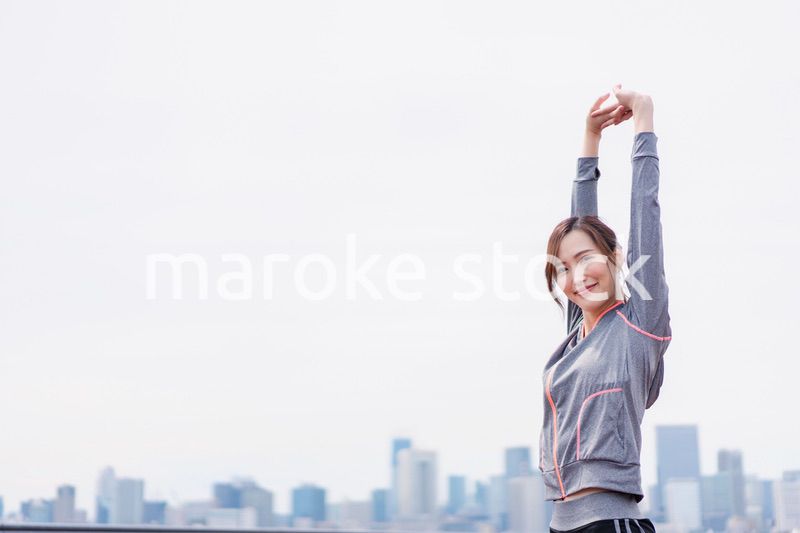 スポーツウェアで深呼吸をする若い女性