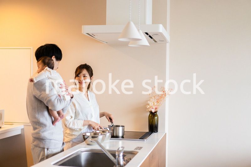 キッチンで料理をするお母さんとお父さんと赤ちゃん