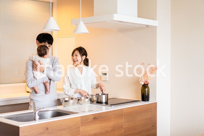 キッチンで料理をするお母さんとお父さんと赤ちゃん