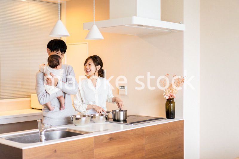 キッチンで料理をするお母さんとお父さんと赤ちゃん