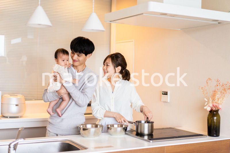 キッチンで料理をするお母さんとお父さんと赤ちゃん
