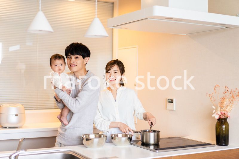キッチンで料理をするお母さんとお父さんと赤ちゃん