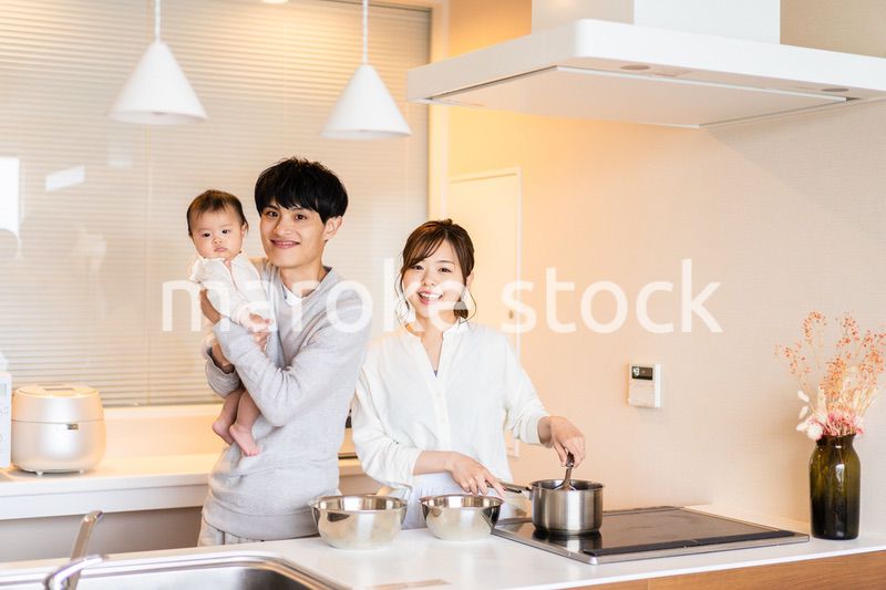 キッチンで料理をするお母さんとお父さんと赤ちゃん