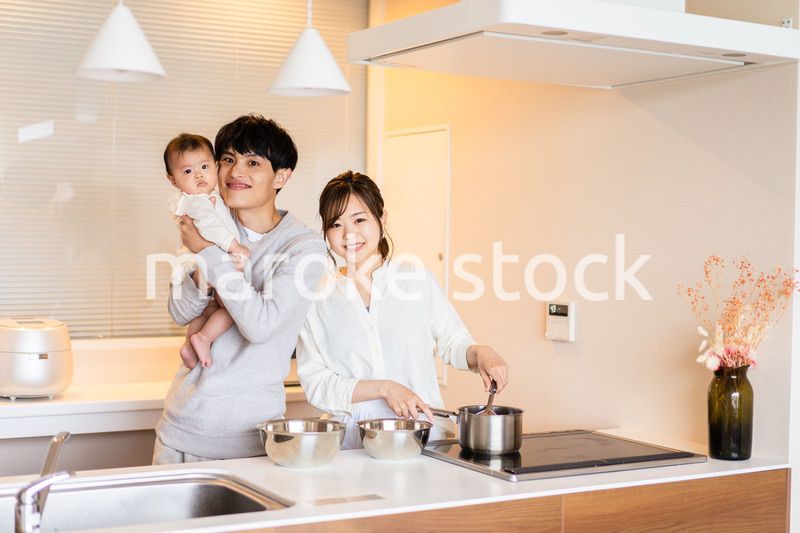 キッチンで料理をするお母さんとお父さんと赤ちゃん