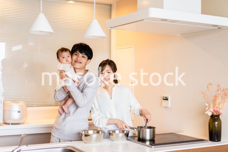 キッチンで料理をするお母さんとお父さんと赤ちゃん