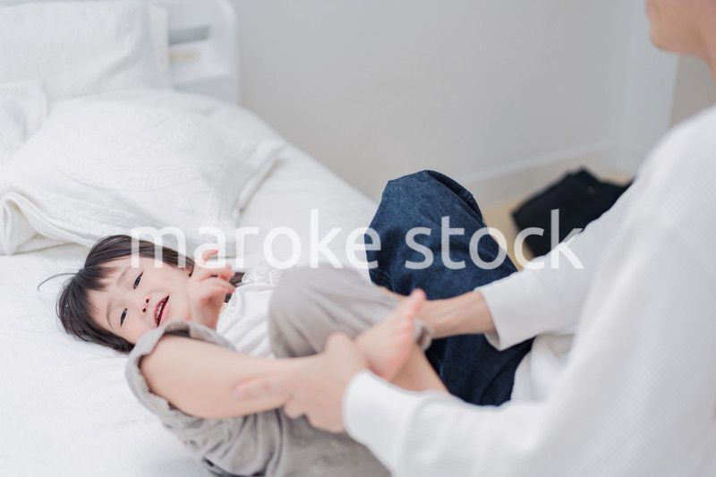 パパと一緒にベッドで遊ぶ小さな女の子