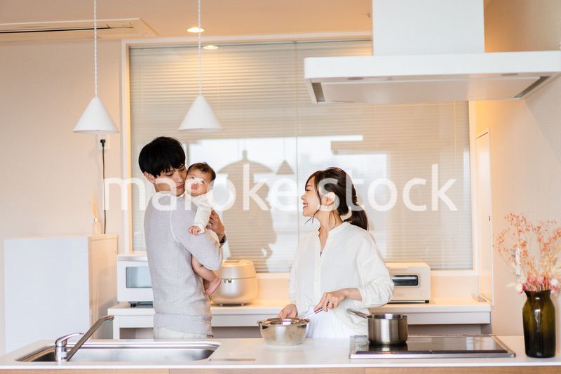 キッチンで料理をするお母さんとお父さんと赤ちゃん