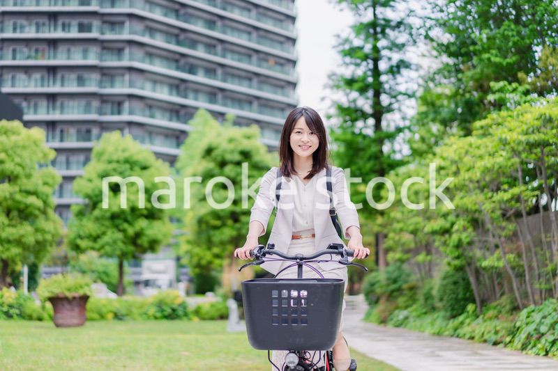 シェアサイクルで通勤をするビジネスウーマン