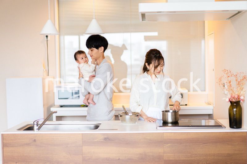 キッチンで料理をするお母さんとお父さんと赤ちゃん