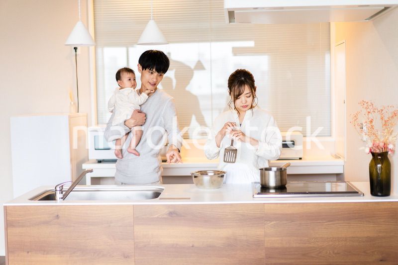 キッチンで料理をするお母さんとお父さんと赤ちゃん