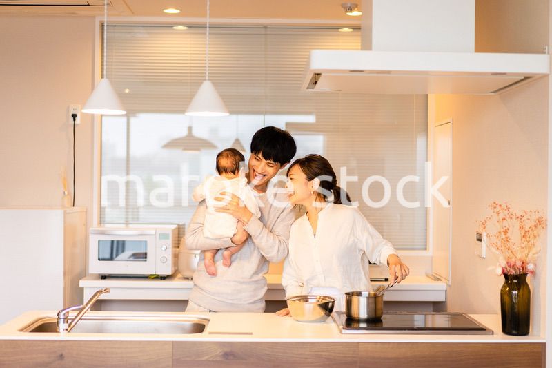 キッチンで料理をするお母さんとお父さんと赤ちゃん