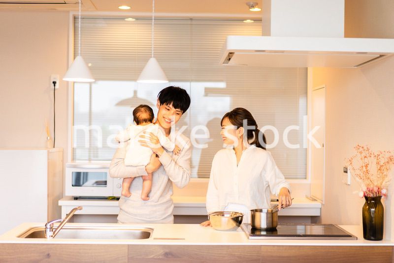 キッチンで料理をするお母さんとお父さんと赤ちゃん