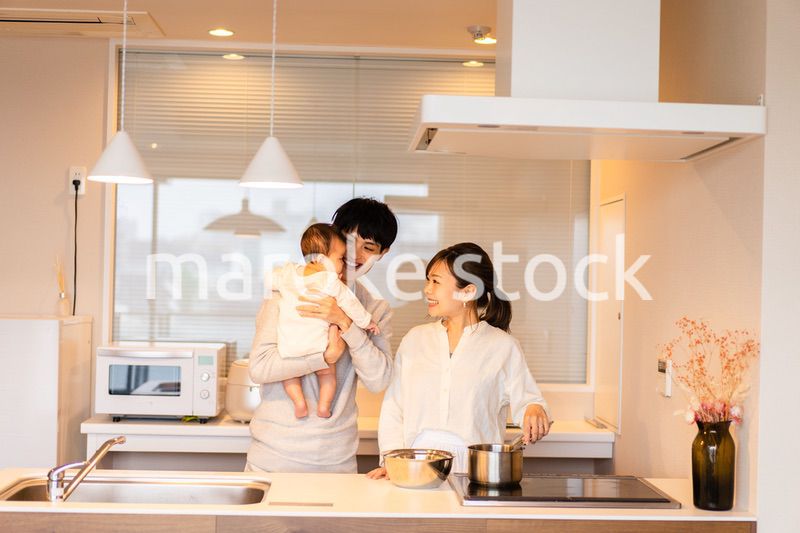 キッチンで料理をするお母さんとお父さんと赤ちゃん