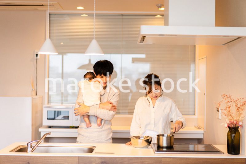 キッチンで料理をするお母さんとお父さんと赤ちゃん
