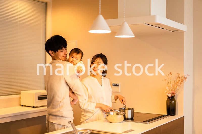 キッチンで料理をするお母さんとお父さんと赤ちゃん