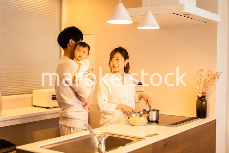 キッチンで料理をするお母さんとお父さんと赤ちゃん