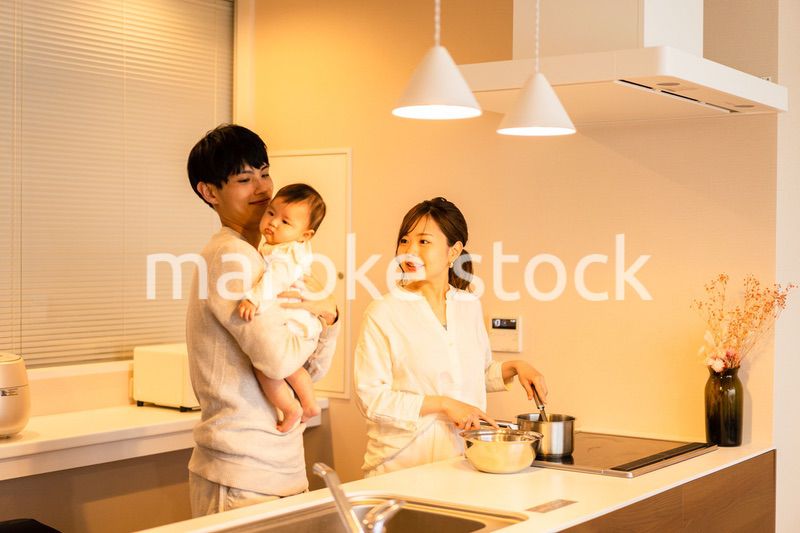キッチンで料理をするお母さんとお父さんと赤ちゃん