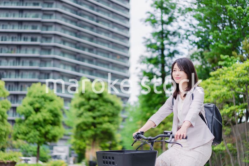 シェアサイクルで通勤をするビジネスウーマン