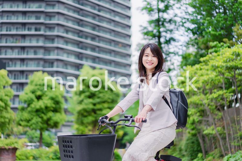 シェアサイクルで通勤をするビジネスウーマン