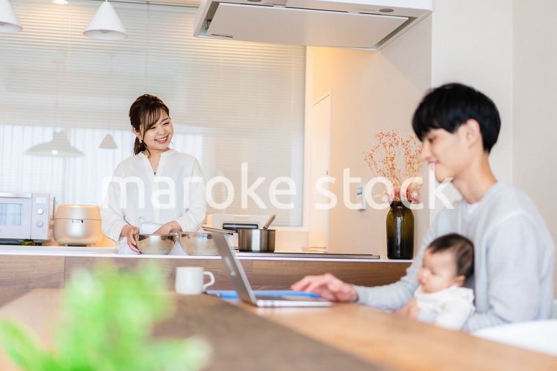 赤ちゃんと一緒にパソコンを使うパパ