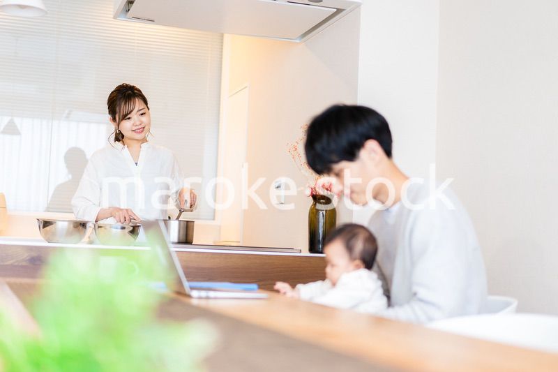 赤ちゃんと一緒にパソコンを使うパパ