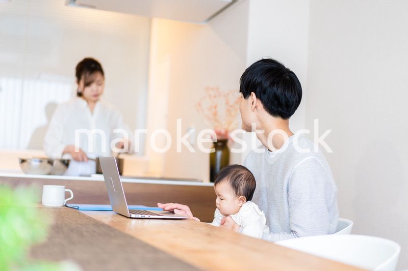 赤ちゃんと一緒にパソコンを使うパパ