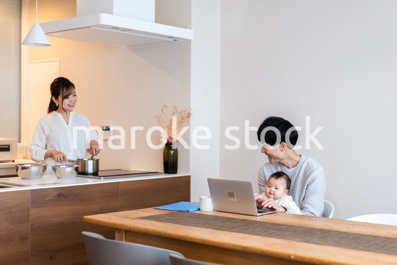 赤ちゃんと一緒にパソコンを使うパパ