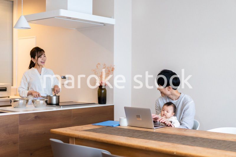 赤ちゃんと一緒にパソコンを使うパパ