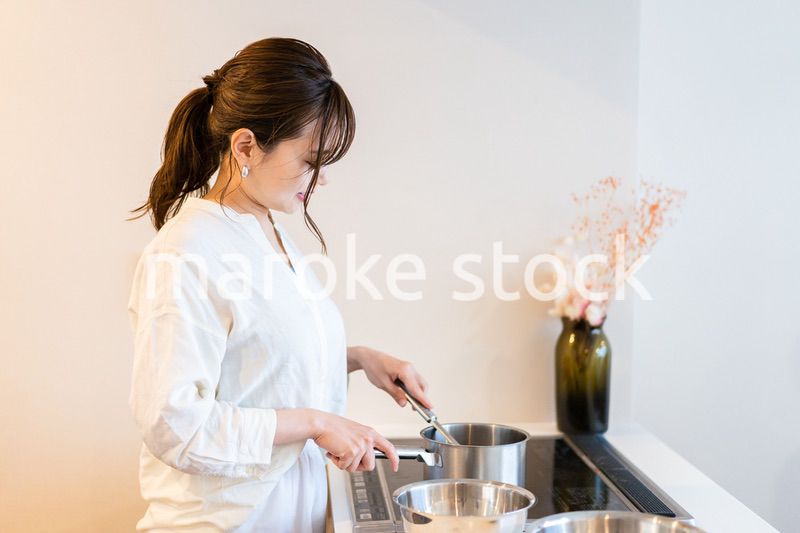 おうちのキッチンで料理をする主婦