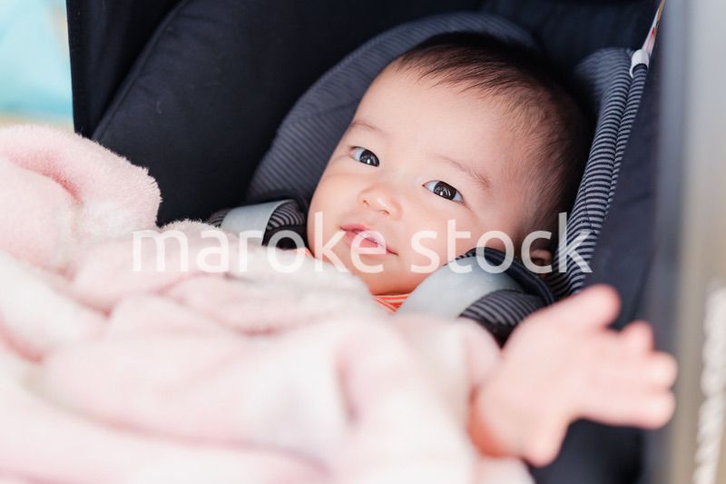 ベビーカーからほほえむ赤ちゃん