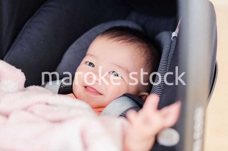 ベビーカーからほほえむ赤ちゃん