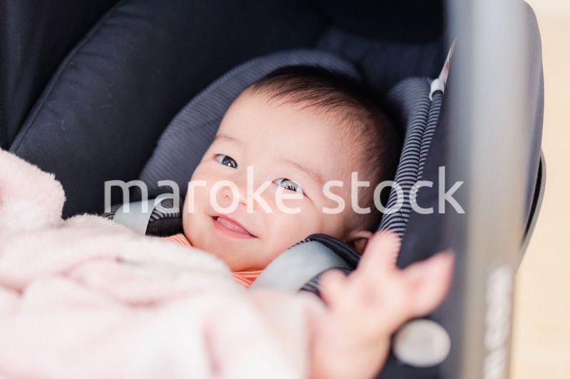 ベビーカーからほほえむ赤ちゃん