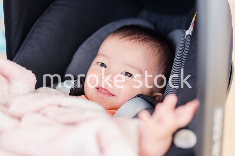 ベビーカーからほほえむ赤ちゃん