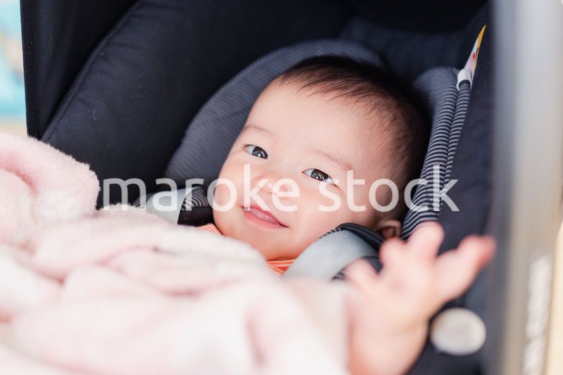 ベビーカーからほほえむ赤ちゃん