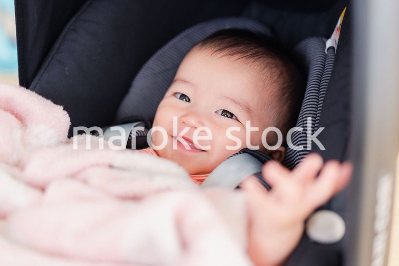 ベビーカーからほほえむ赤ちゃん